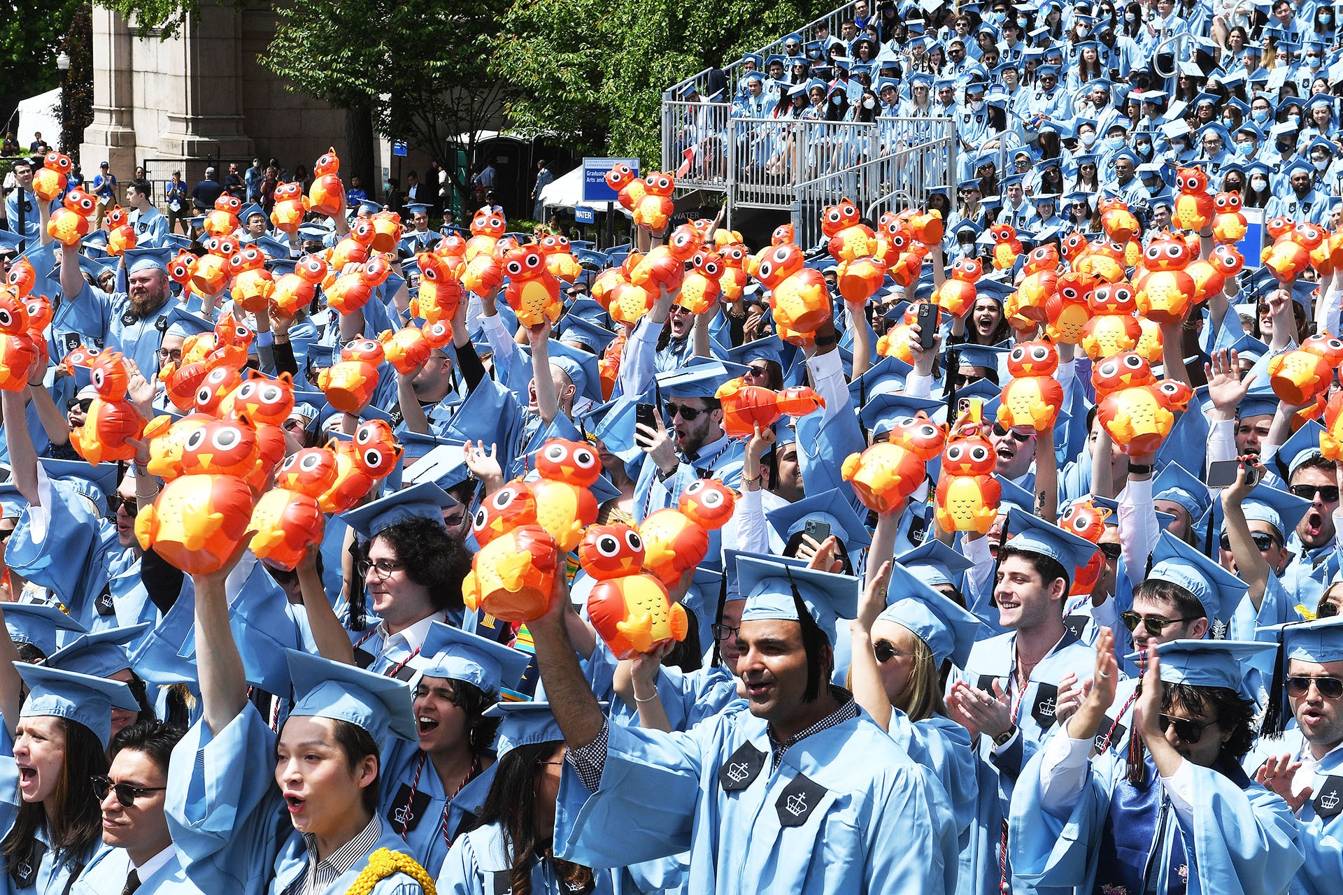 Columbia GS graduates hold up inflatable owls at the 2022 University Commencement ceremony