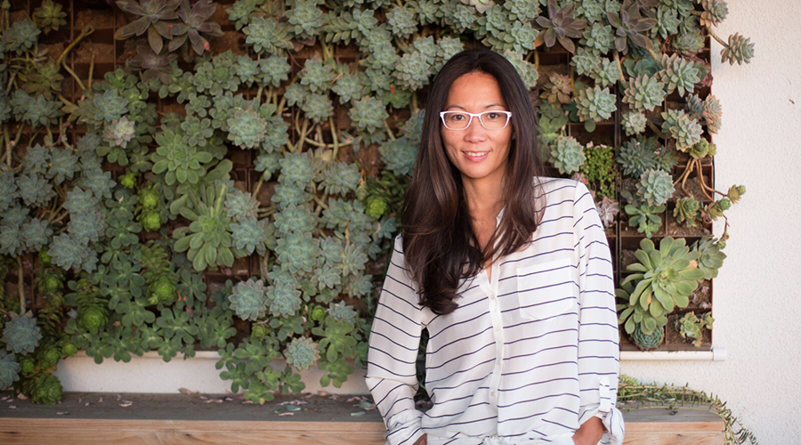 GS alumna Kikka Hanazawa '00 poses in front of a wall of plants