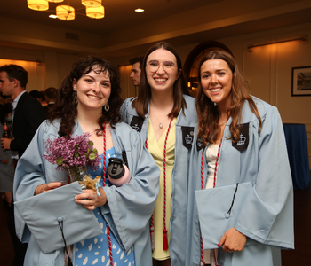 Three Dual BA graduates smile at the camera