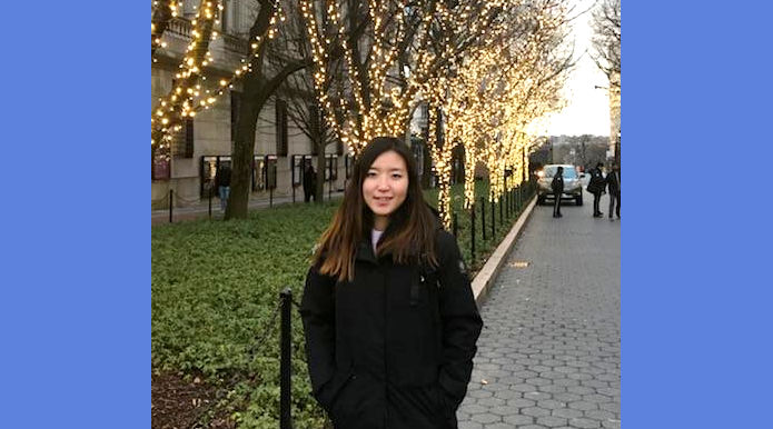 Gilsun Won standing on College Walk, surrounded by trees decorated with holiday lights