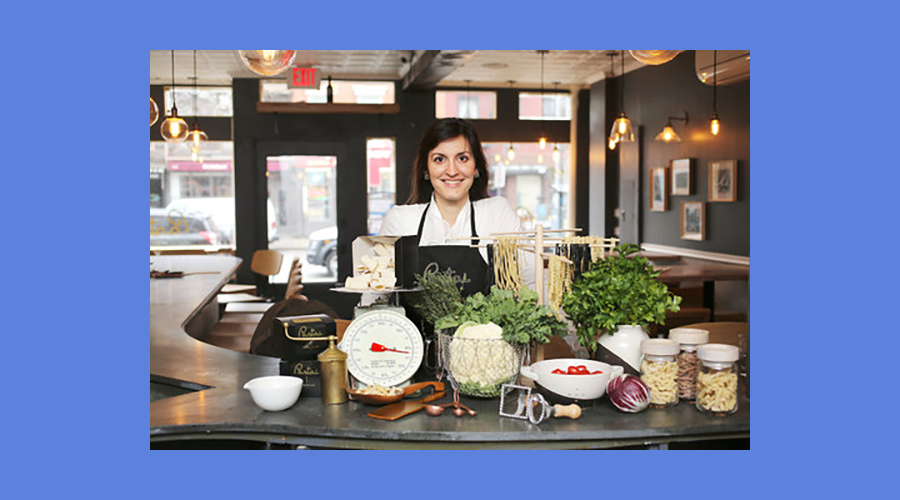 Melissa Muller Daka poses in front of some fresh pasta inside her restaurant, Pastai