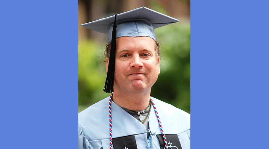 Jason Everman in his blue Columbia graduation gown
