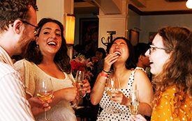 Attendees share a laugh at the reception for Dual/Joint Degree and Postbac Premed Program alumni Four guests laugh at the reception for Dual and Joint Degree Program and Postbac Premed Program alumni