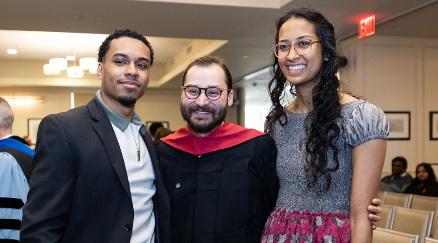 Three attendees (including student speaker Wesley Rey Rivera, middle) at the 2024 Postbac Premed Class Day Ceremony