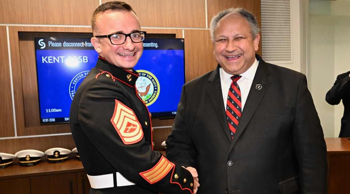 Columbia GS student Isaiah Nagelkerk, an active duty Marine in the Enlisted Commissioning Education Program, shakes hands with Secretary of the Navy Carlos Del Toro.
