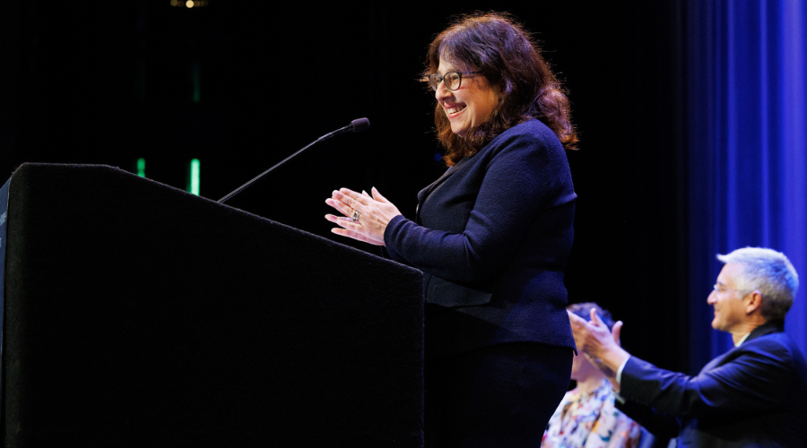 Dean Rosen-Metsch standing on stage and greeting the incoming GS students