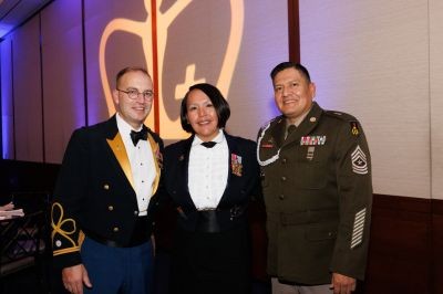 three guests at the military ball standing in front of the columbia logo