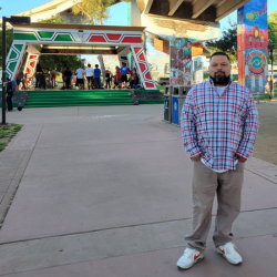 Enrique Ortiz in the Barrio Logan neighborhood surrounded by local murals