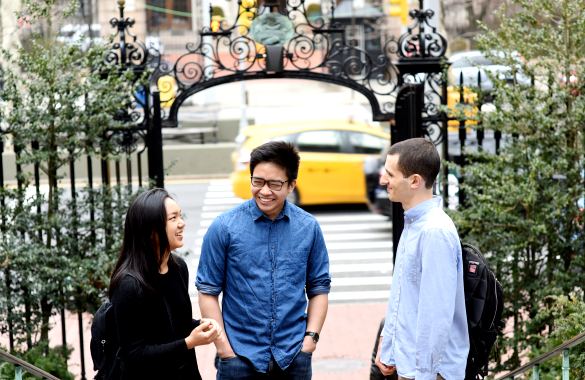 Students chat with Earl Gate in the background as a yellow taxi drives by