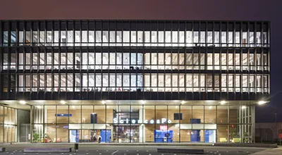 View at night of the library at the Sciences Po Le Havre campus lit from the interior