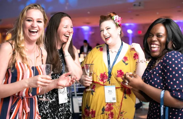 Four laughing women celebrate with champagne at the GS Annual Alumni Dinner as part of Columbia Reunion