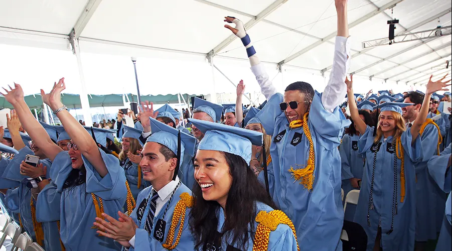 Several members of the graduate seating area celebrating their graduation during the GS Class Day ceremony