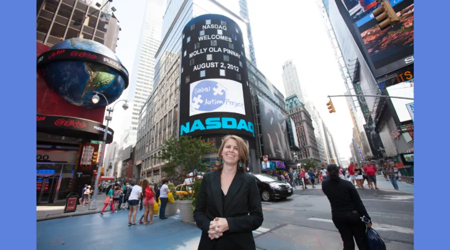 GS alumna Molly Ola Pinney stands in front of the NASDAQ sign in New York City 