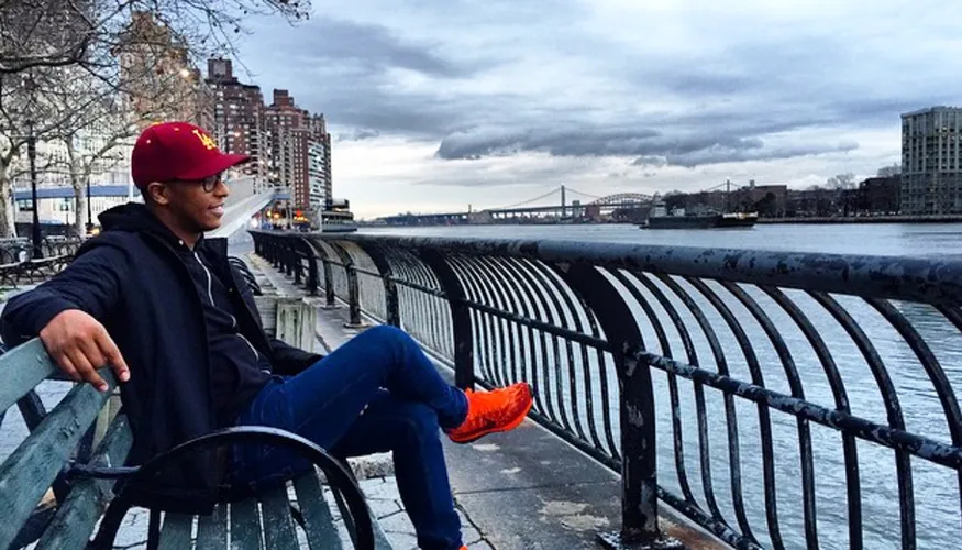 C. Craig Patterson sits on a bench overlooking a river