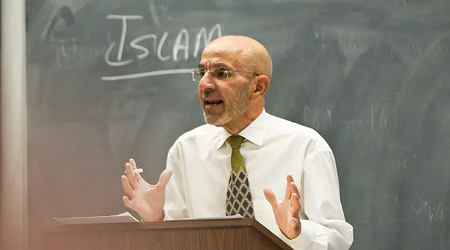 Dean Peter J. Awn lectures in front a blackboard