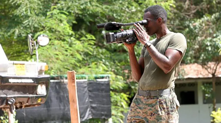 Elegance Bratton holding a camera on an outside video shoot