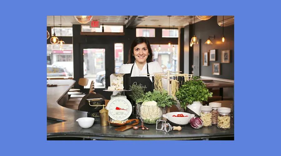 Melissa Muller Daka poses in front of some fresh pasta inside her restaurant, Pastai