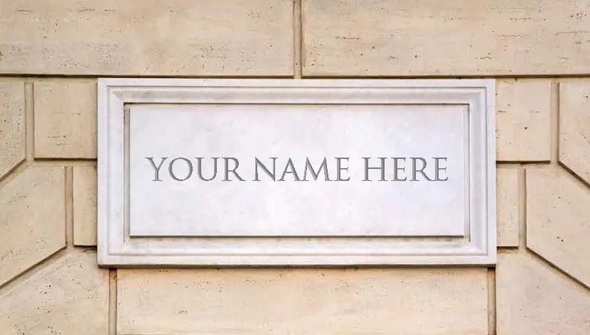 Placard on the side of a building that reads "Your Name Here"