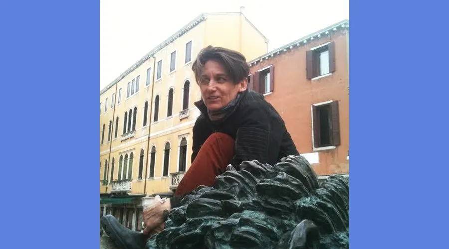 Valerie Fendt sits outside in front of a yellow building