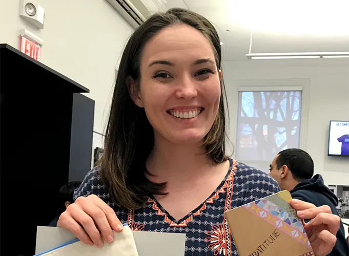 A volunteer displays her custom made notebook and pencil case. 