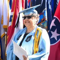 Columbia GS graduate Lisa Delgado Smith '25GS poses in front of flags at Class Day.